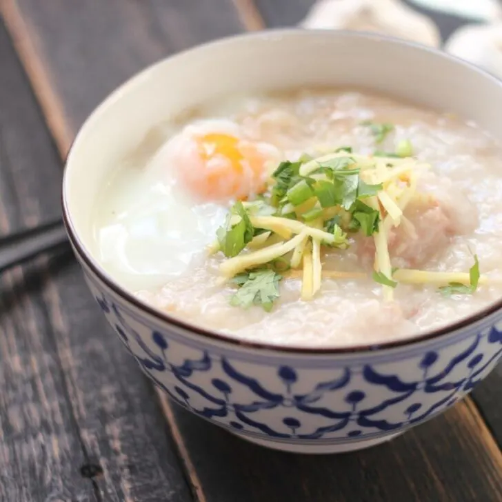 Instant Pot Arroz Caldo aka Lugaw in a bowl on a table garnished with egg